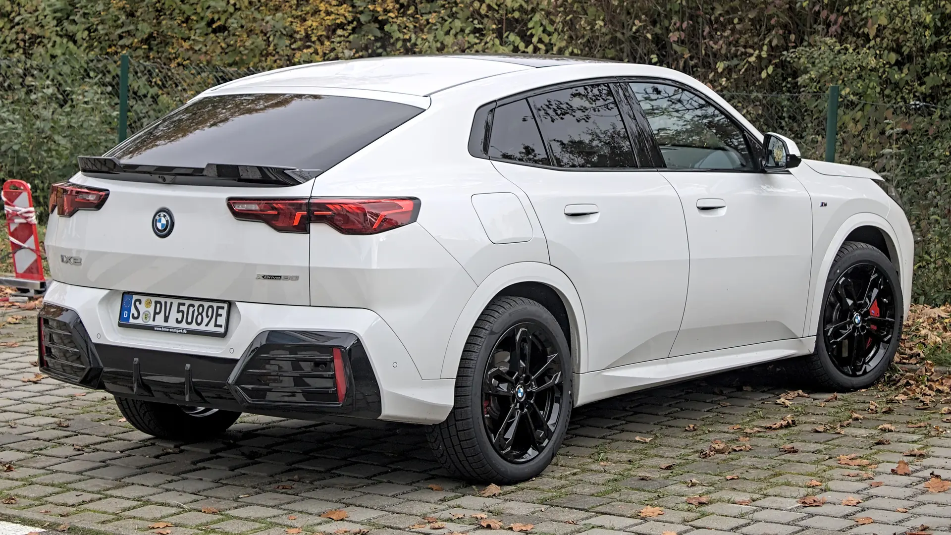 Een witte BMW iX2, schuin van voren, op een parkeerplaats