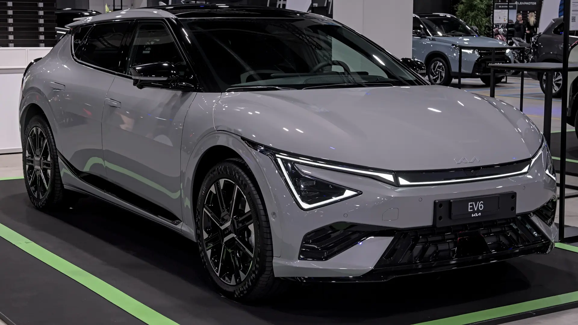 Een grijze Kia EV6 GT-Line, schuin van voren, op een autobeurs