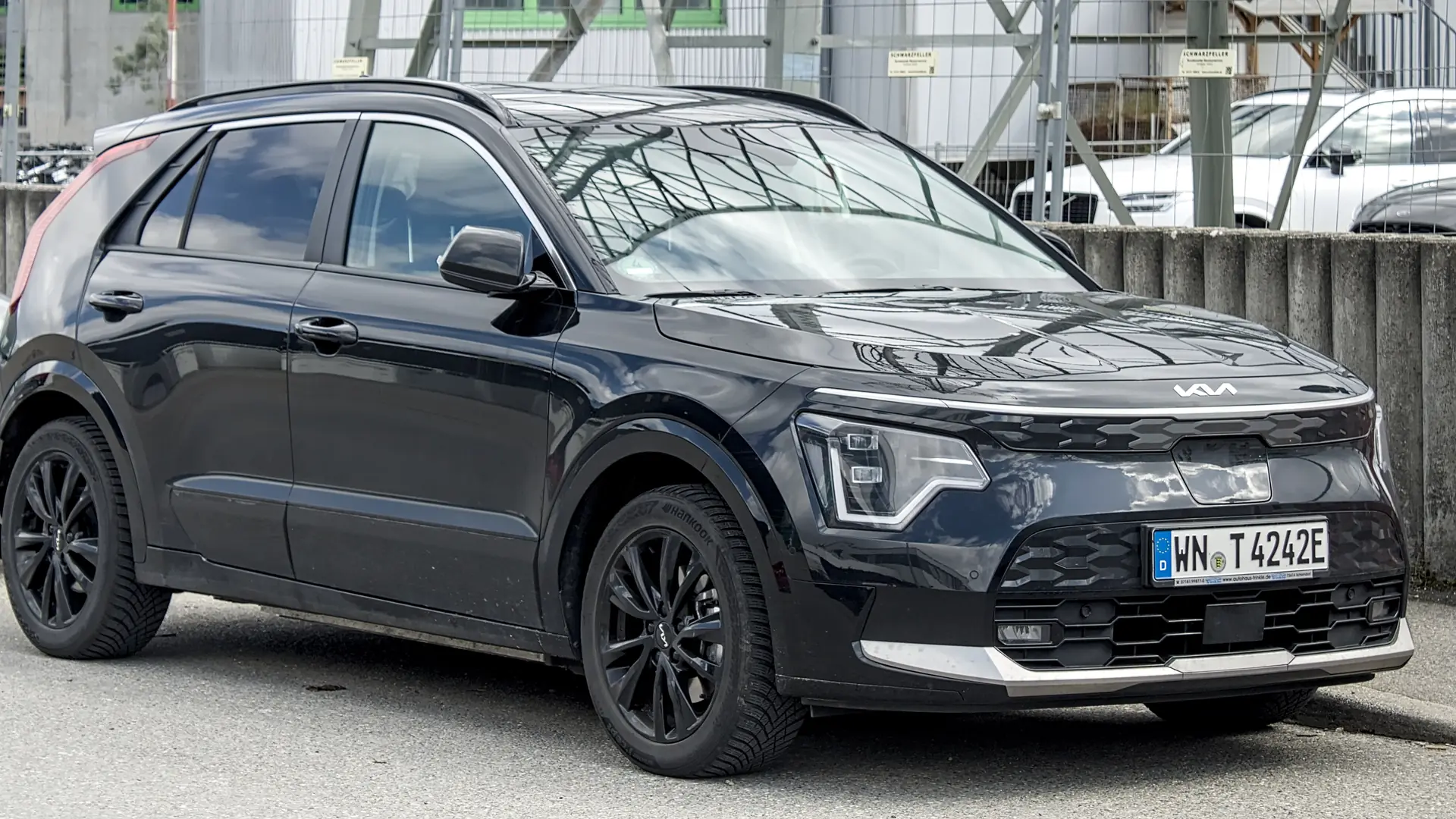 Een zwarte Kia Niro EV, schuin van voren, geparkeerd op straat